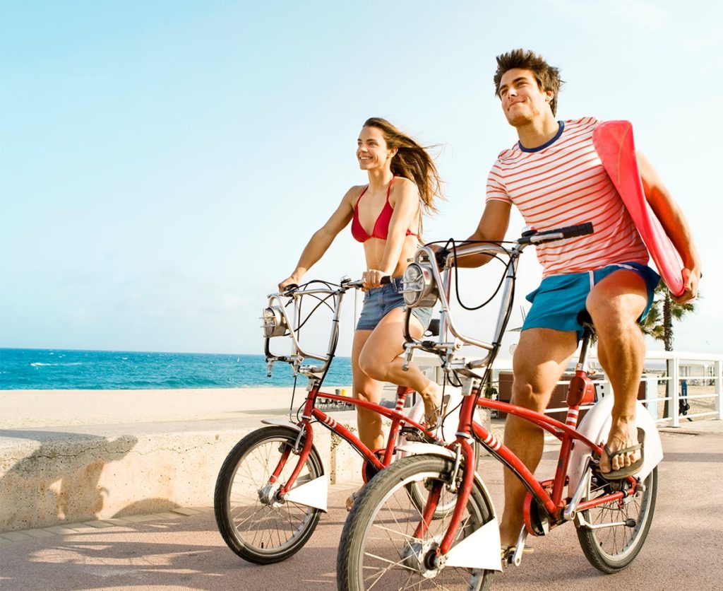 Young couple riding bike around Cancun Hotel Zone