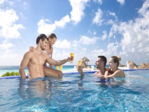 Two couples having drinks together in Golden Parnassus Cancun pool