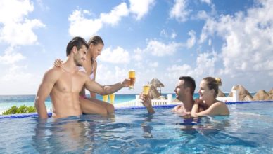 Two couples having drinks together in Golden Parnassus Cancun pool
