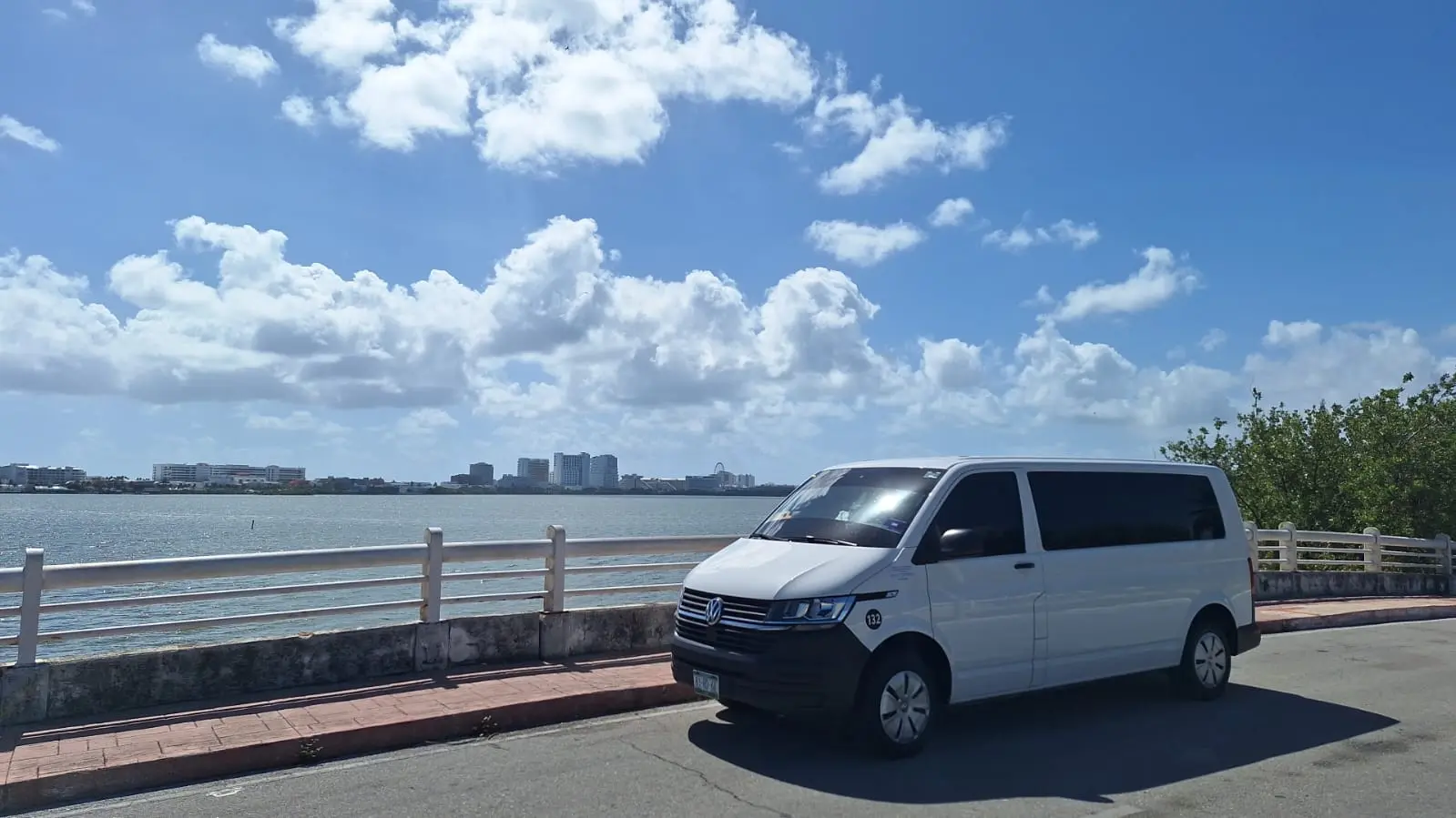 A van parked on a bridge in Cancun offering private transportation services. 