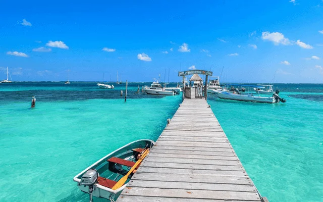 A dock over turquoise waters of Puerto Morelos' beach. One of the destinations available for Cancun Airport Transportation