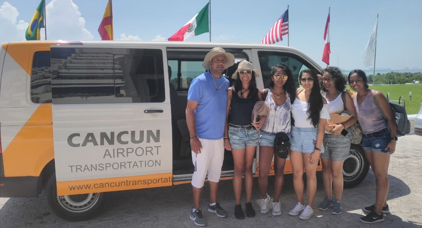 Group of six happy customers wearing sunglasses in front of a Private Transportation van
