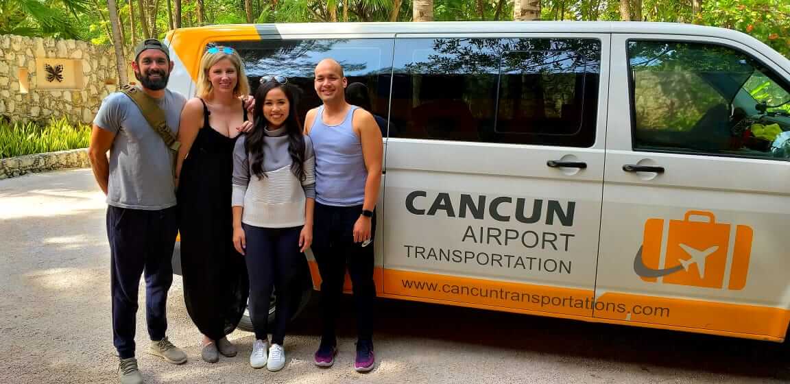 Group of friends smiling in front of a van labeled by Cancun Airport Transportation