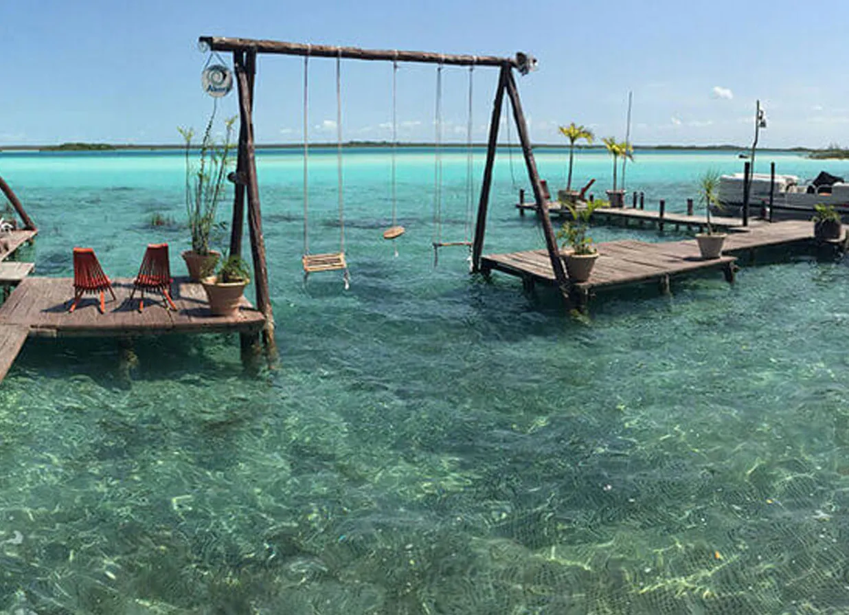 Wood swings at Bacalar beach. One of the destinations available for Cancun Airport Transportation