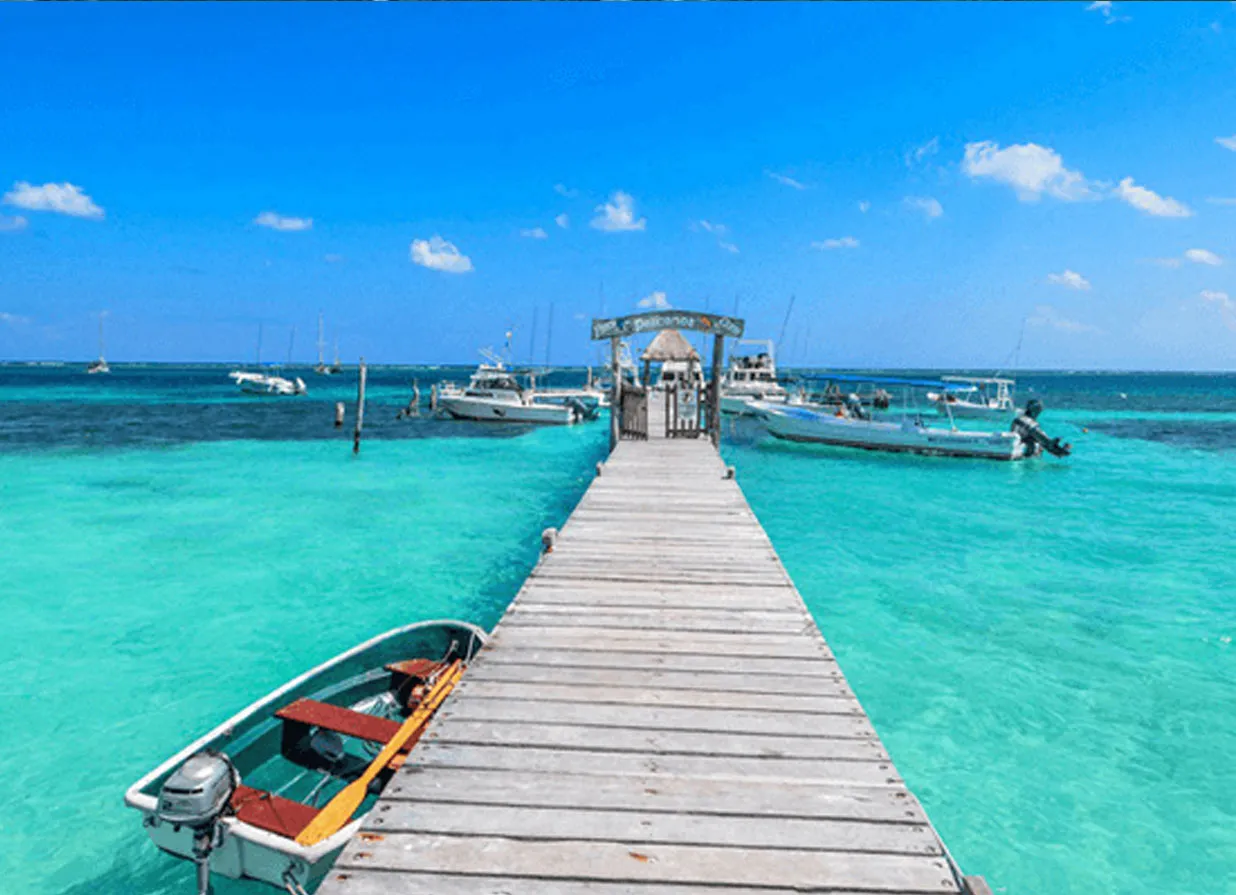 A dock over turquoise waters of Puerto Morelos' beach. One of the destinations available for Cancun Airport Transportation